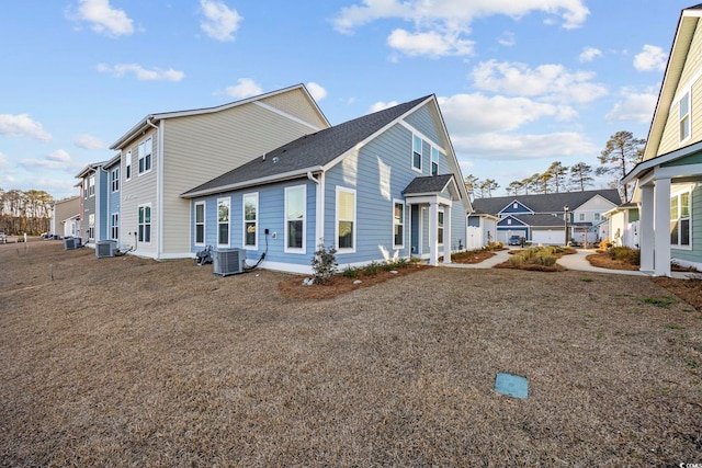 view of side of home featuring a residential view, a lawn, and central air condition unit