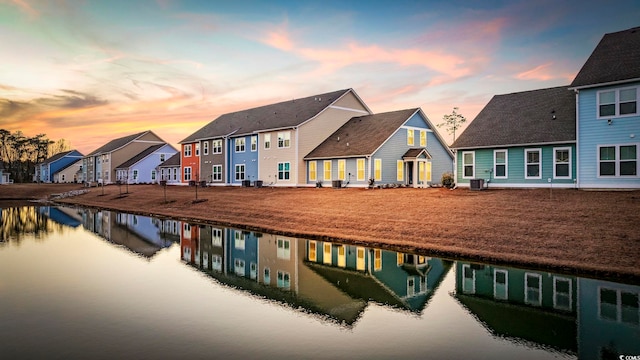 back of house with a water view, cooling unit, and a residential view