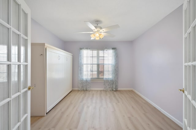 empty room with light hardwood / wood-style flooring, ceiling fan, and french doors