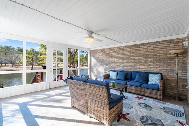 sunroom / solarium with a water view and ceiling fan