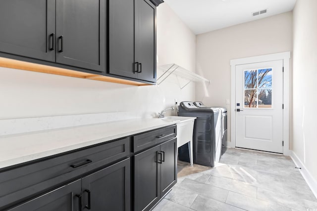 laundry room with cabinets, sink, and washing machine and clothes dryer