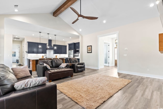 living room featuring beamed ceiling, ceiling fan, wood-type flooring, and high vaulted ceiling