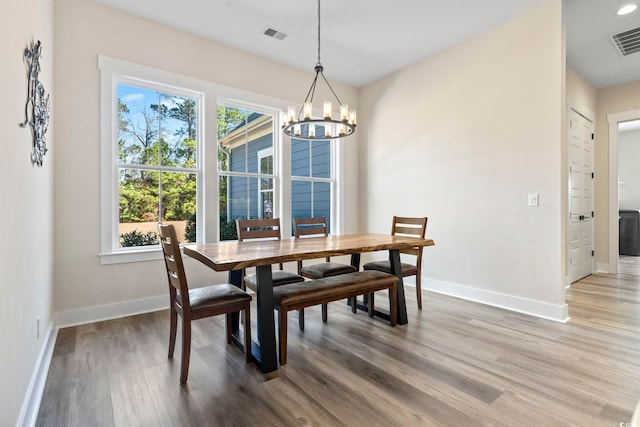 dining space featuring hardwood / wood-style flooring and a notable chandelier