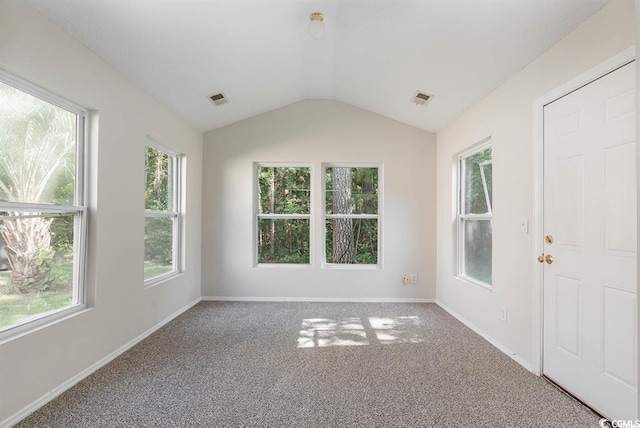 carpeted spare room with vaulted ceiling