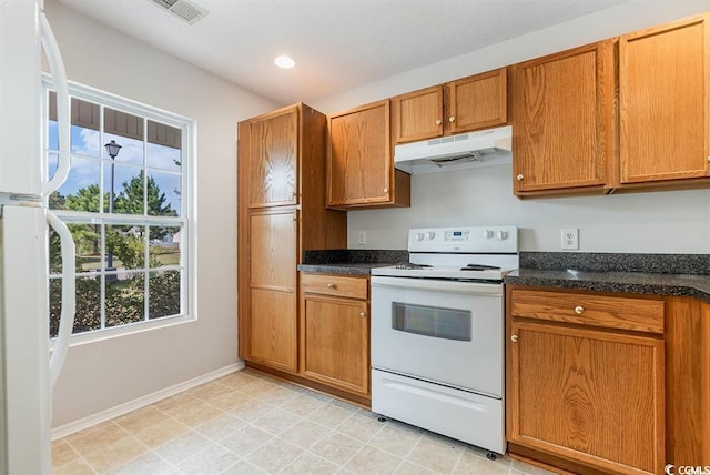 kitchen featuring white appliances and dark stone counters