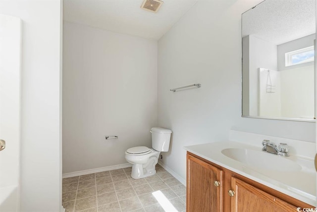 bathroom featuring vanity, a textured ceiling, tile patterned floors, and toilet