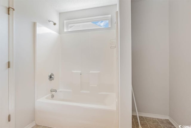 bathroom featuring bathtub / shower combination, tile patterned flooring, and a textured ceiling