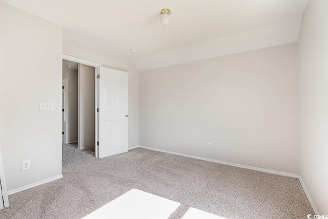 empty room with lofted ceiling and light carpet