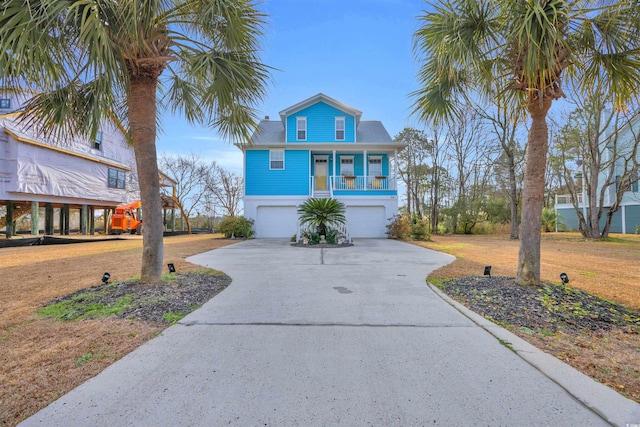 raised beach house featuring a garage and covered porch