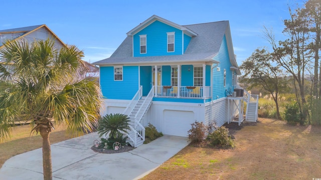 coastal home featuring central AC unit, a garage, and a porch