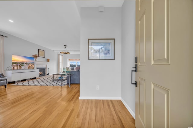 foyer entrance with a fireplace and light hardwood / wood-style flooring