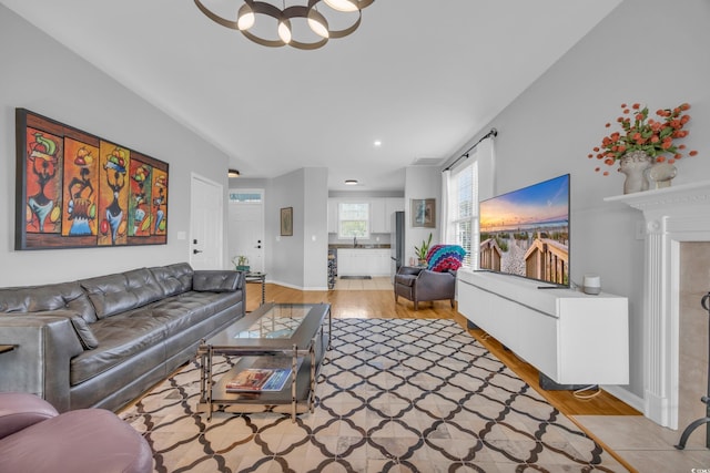 living room with an inviting chandelier and light hardwood / wood-style flooring