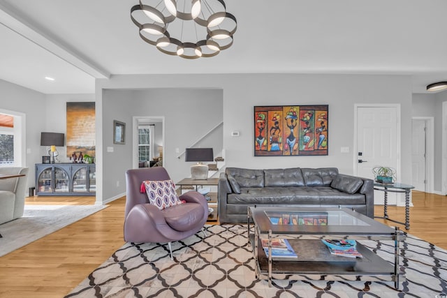 living room featuring a notable chandelier and light hardwood / wood-style flooring