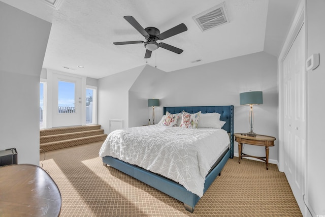 carpeted bedroom featuring a closet, vaulted ceiling, and ceiling fan