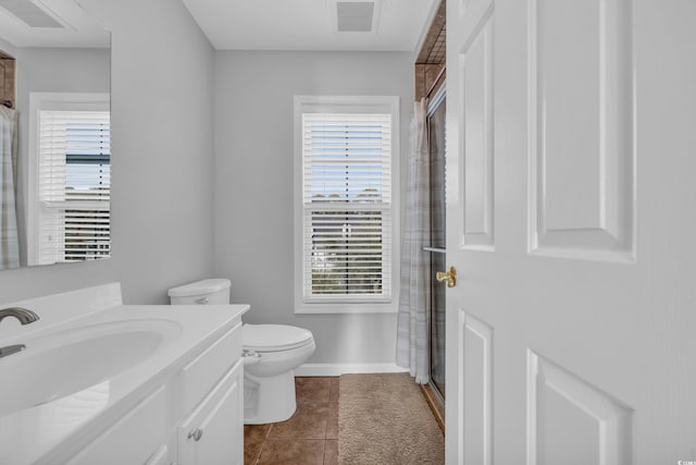 bathroom with vanity, an enclosed shower, toilet, and tile patterned floors