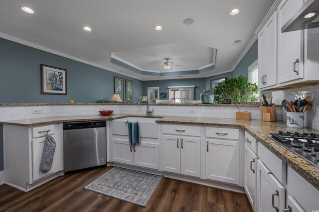 kitchen with sink, stainless steel appliances, ornamental molding, white cabinets, and kitchen peninsula