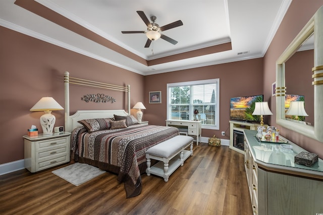 bedroom with ceiling fan, ornamental molding, dark hardwood / wood-style floors, and a raised ceiling