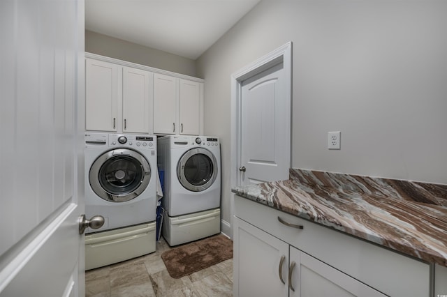 laundry area with washer and clothes dryer and cabinets