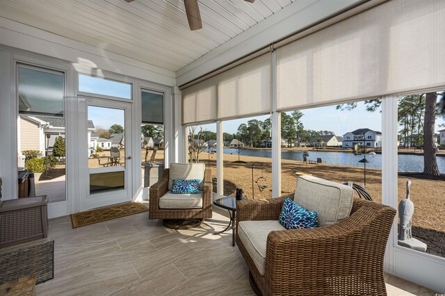 sunroom featuring a water view and ceiling fan