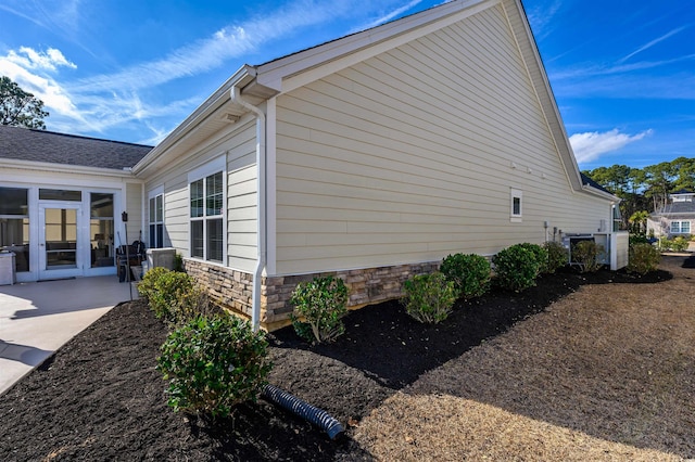 view of property exterior with french doors and a patio area