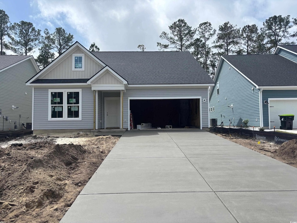 craftsman house featuring a garage, central AC, board and batten siding, and concrete driveway