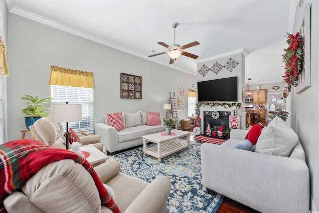 living area featuring ceiling fan, a glass covered fireplace, crown molding, and wood finished floors