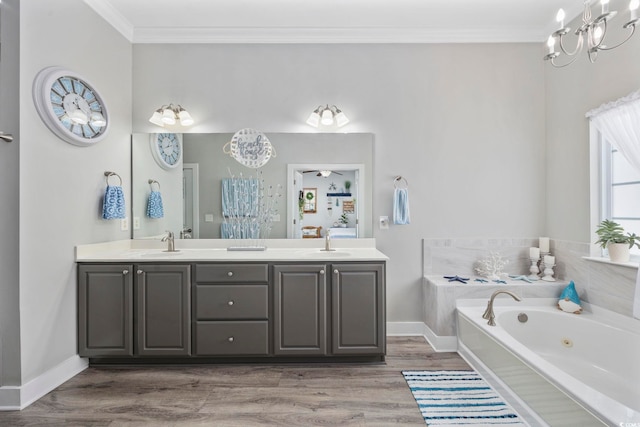 bathroom featuring double vanity, a tub with jets, ornamental molding, and a sink