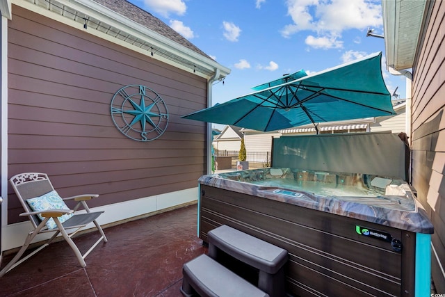 view of patio / terrace featuring fence and a hot tub