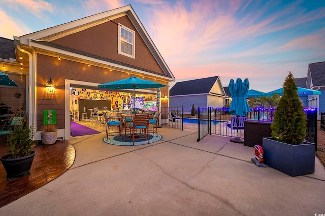 patio terrace at dusk featuring fence