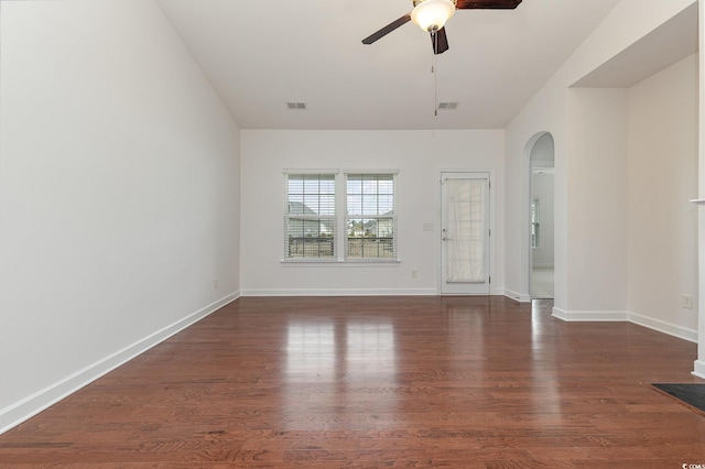 unfurnished room with a ceiling fan, visible vents, wood finished floors, and arched walkways