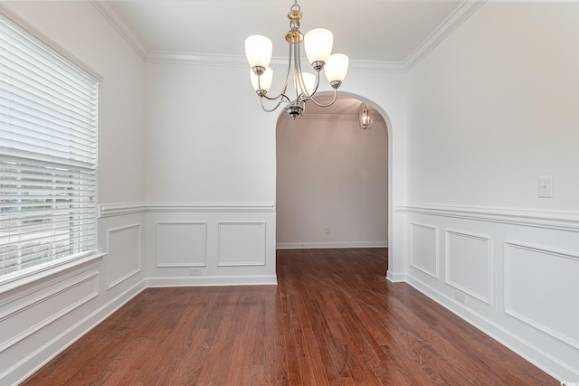 unfurnished dining area with arched walkways, wood finished floors, and crown molding