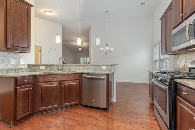 kitchen with a wealth of natural light, wood finished floors, appliances with stainless steel finishes, and a sink