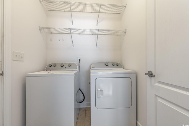 washroom with washer and dryer, laundry area, and light tile patterned floors