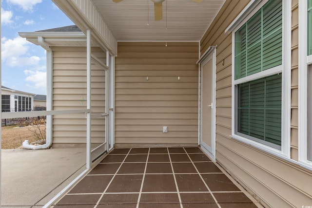 unfurnished sunroom with a ceiling fan