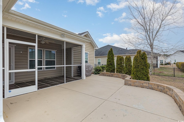 view of patio / terrace featuring fence, a ceiling fan, and a sunroom