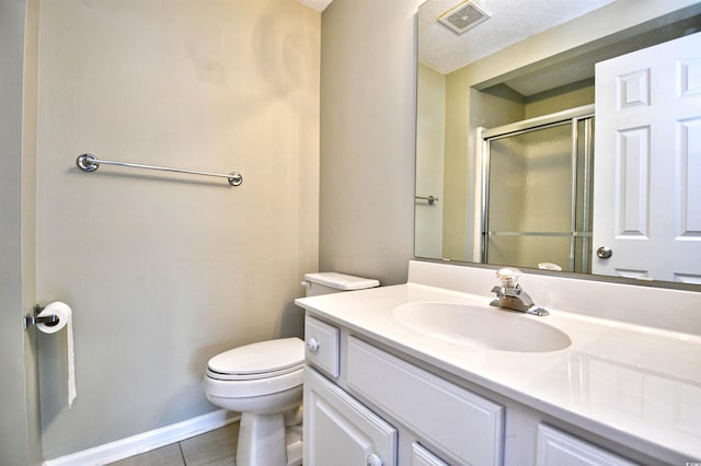 full bath featuring a stall shower, tile patterned flooring, toilet, vanity, and a textured ceiling