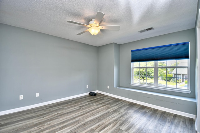 spare room with wood finished floors, baseboards, a ceiling fan, and a textured ceiling