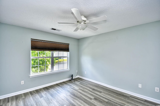 spare room with wood finished floors, a textured ceiling, ceiling fan, and baseboards