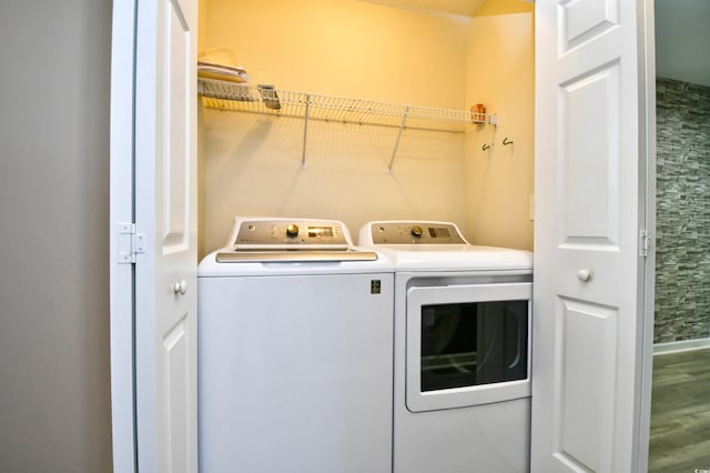 clothes washing area featuring separate washer and dryer and wood finished floors