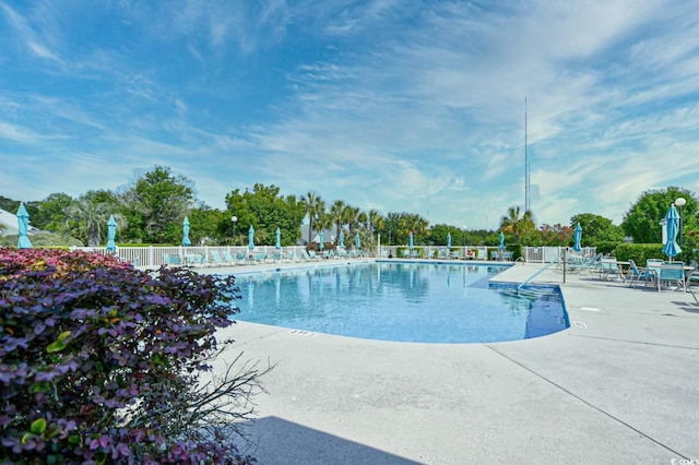 community pool featuring fence and a patio