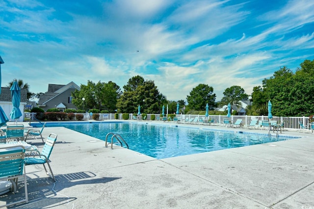 community pool featuring fence and a patio