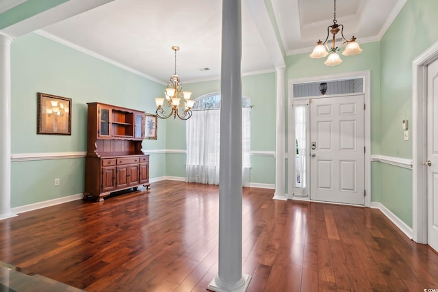 foyer featuring an inviting chandelier, dark hardwood / wood-style floors, and decorative columns