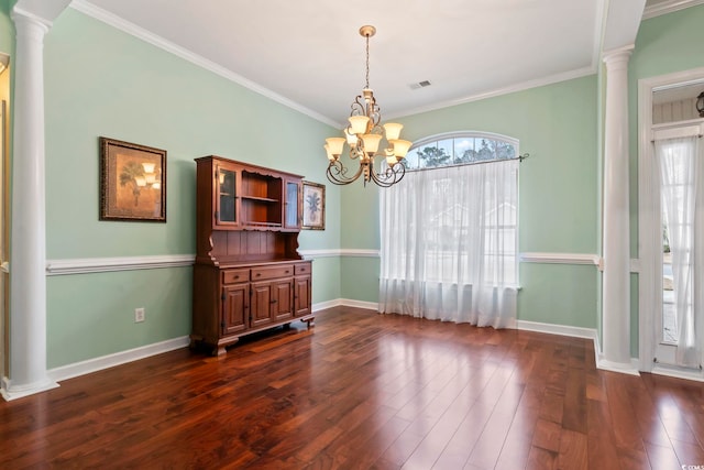 unfurnished dining area with an inviting chandelier, ornamental molding, dark hardwood / wood-style flooring, and ornate columns