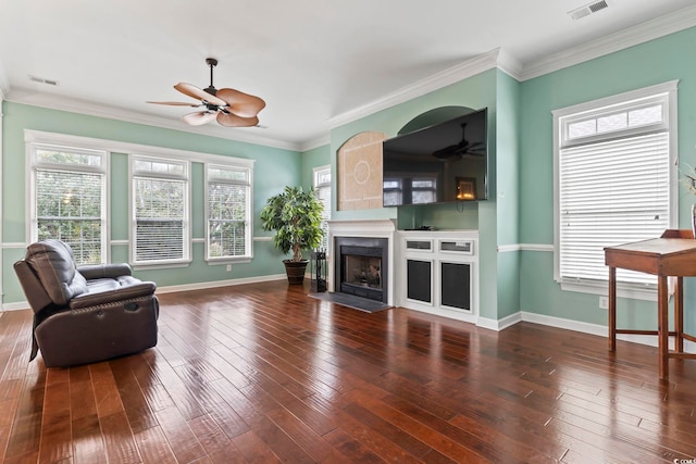 living room featuring visible vents, ceiling fan, wood-type flooring, and a fireplace with flush hearth