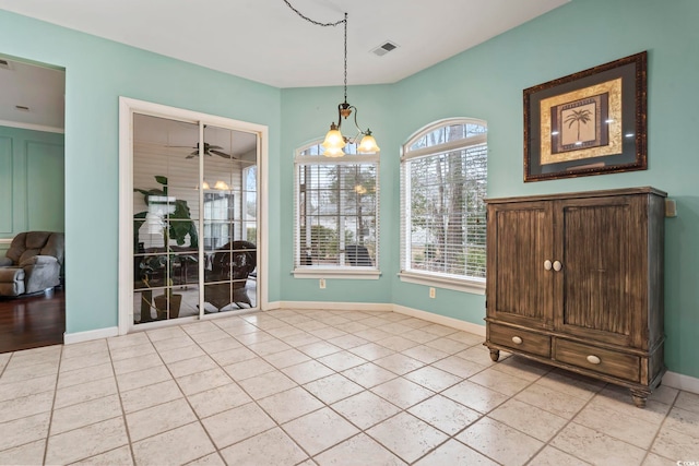 unfurnished dining area with an inviting chandelier and light tile patterned floors