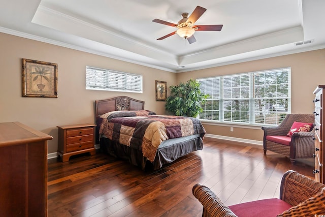 bedroom with ornamental molding, dark hardwood / wood-style floors, and a raised ceiling