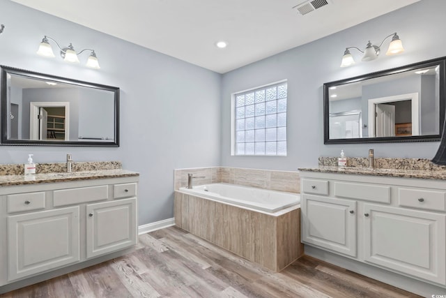 bathroom with hardwood / wood-style flooring, vanity, and independent shower and bath