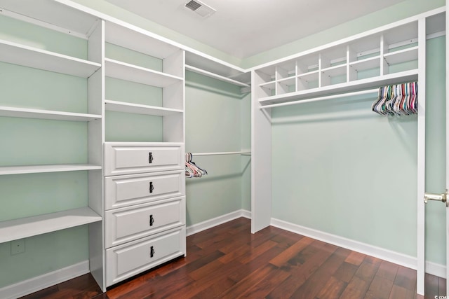 spacious closet featuring dark hardwood / wood-style flooring