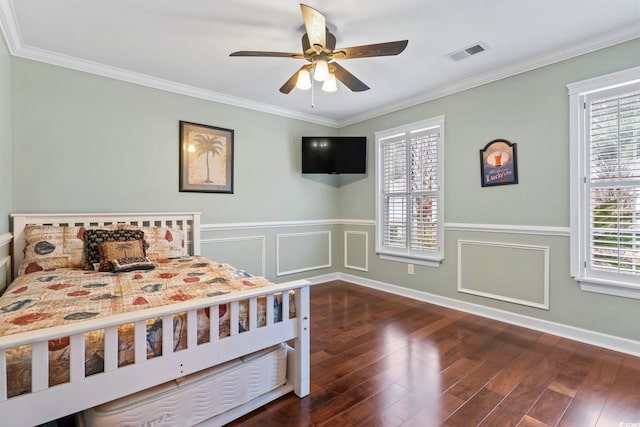 bedroom with dark wood-type flooring, crown molding, and multiple windows