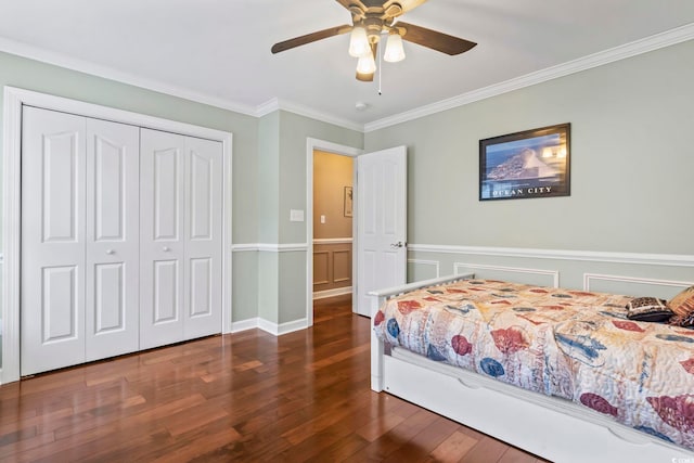 bedroom featuring a closet, crown molding, a wainscoted wall, a ceiling fan, and wood finished floors